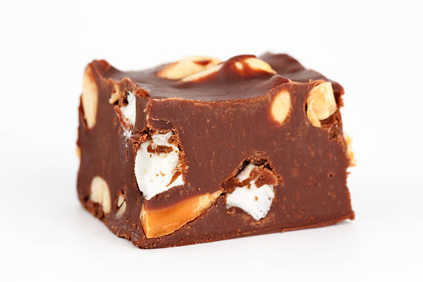 Block of homemade chocolate fudge with peanuts and marshmallows.  Isolated on white background.